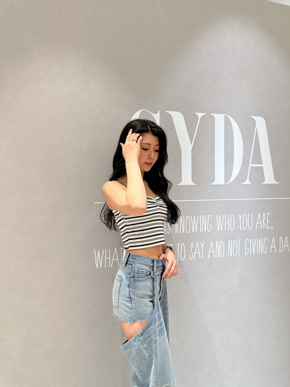 ホワイト系のキャミソール、ブルー系のデニムパンツ、ホワイト系のサンダルを着用したレディースの夏コーディネートの3枚目の写真