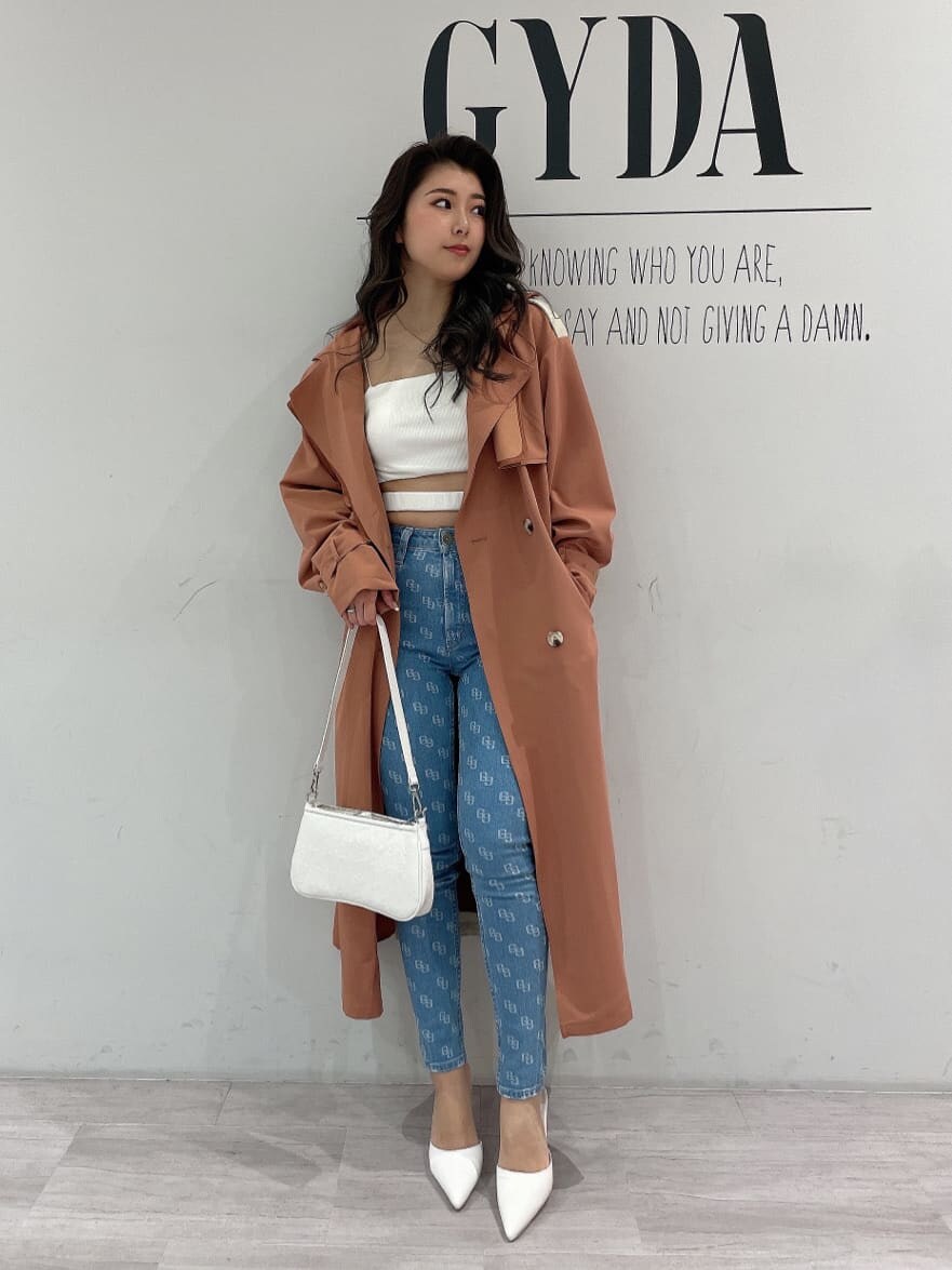 ホワイト系のキャミソール、ホワイト系のパンプス、オレンジ系のトレンチコートを着用したレディースの春コーディネートの2枚目の写真