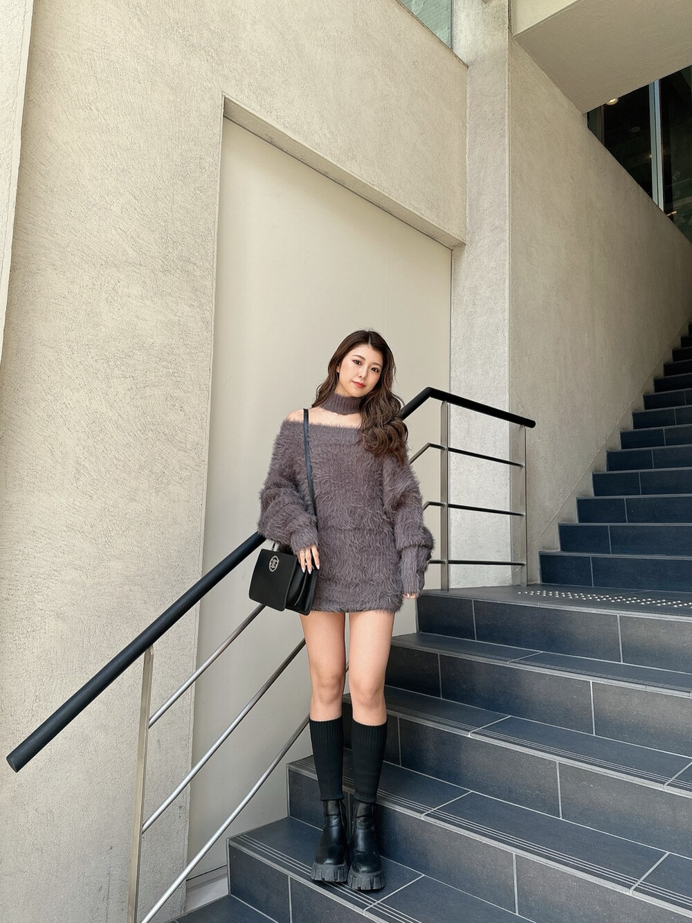 ホワイト系のニット/セーター、ブラック系のスカート、ブラック系のブーツを着用したレディースの冬コーディネートの4枚目の写真