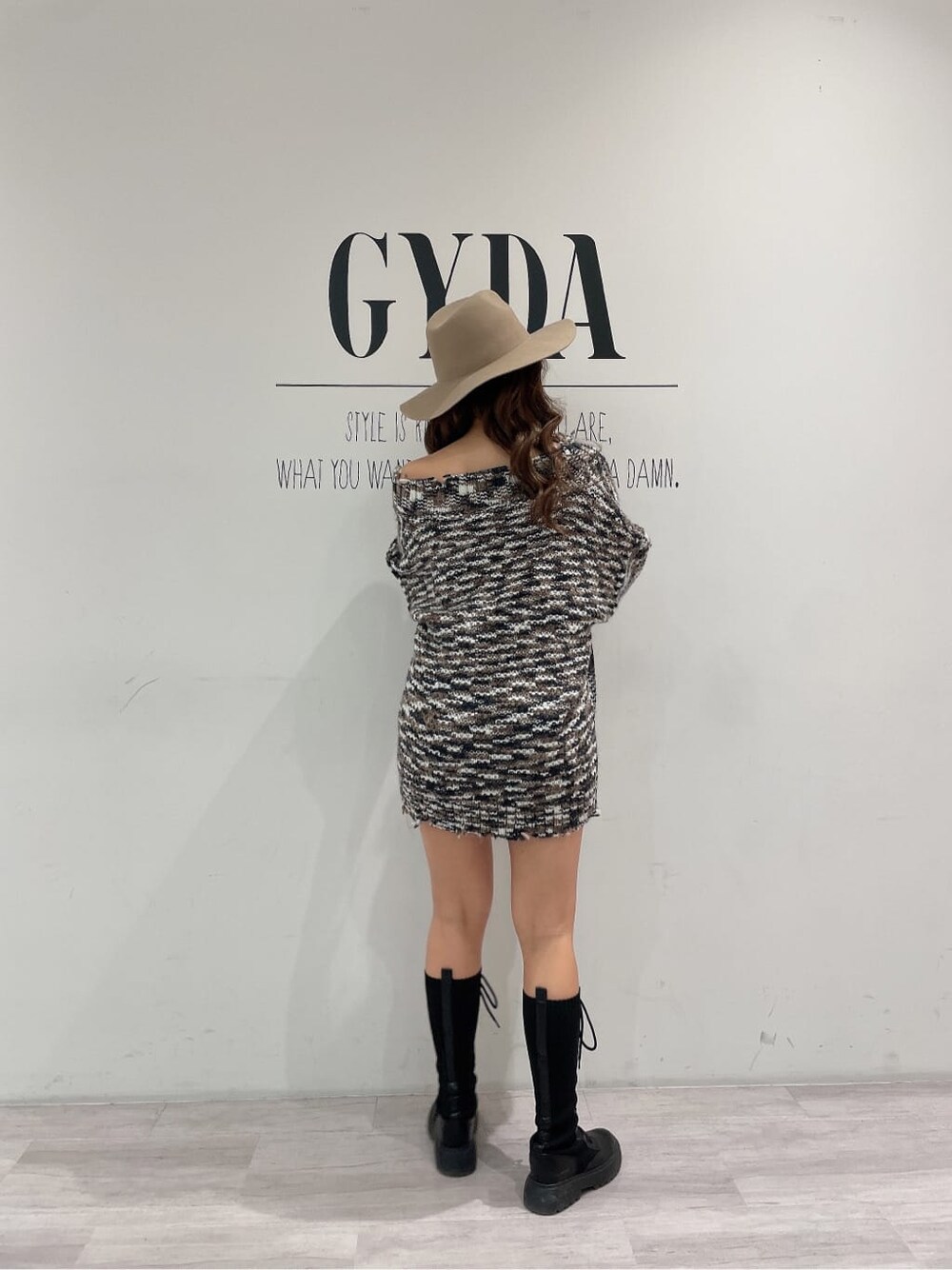 ブラック系のブーツ、ブラック系のデニムパンツ、グレー系のニット/セーターを着用したレディースの秋コーディネートの3枚目の写真