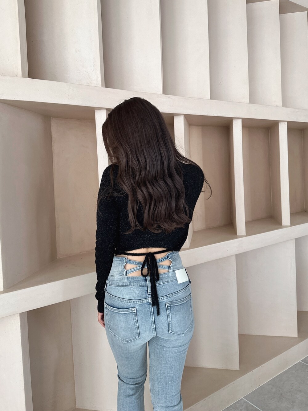 ブラック系のブーツ、ブルー系のデニムパンツ、ブラック系のニット/セーターを着用したレディースの秋コーディネートの6枚目の写真