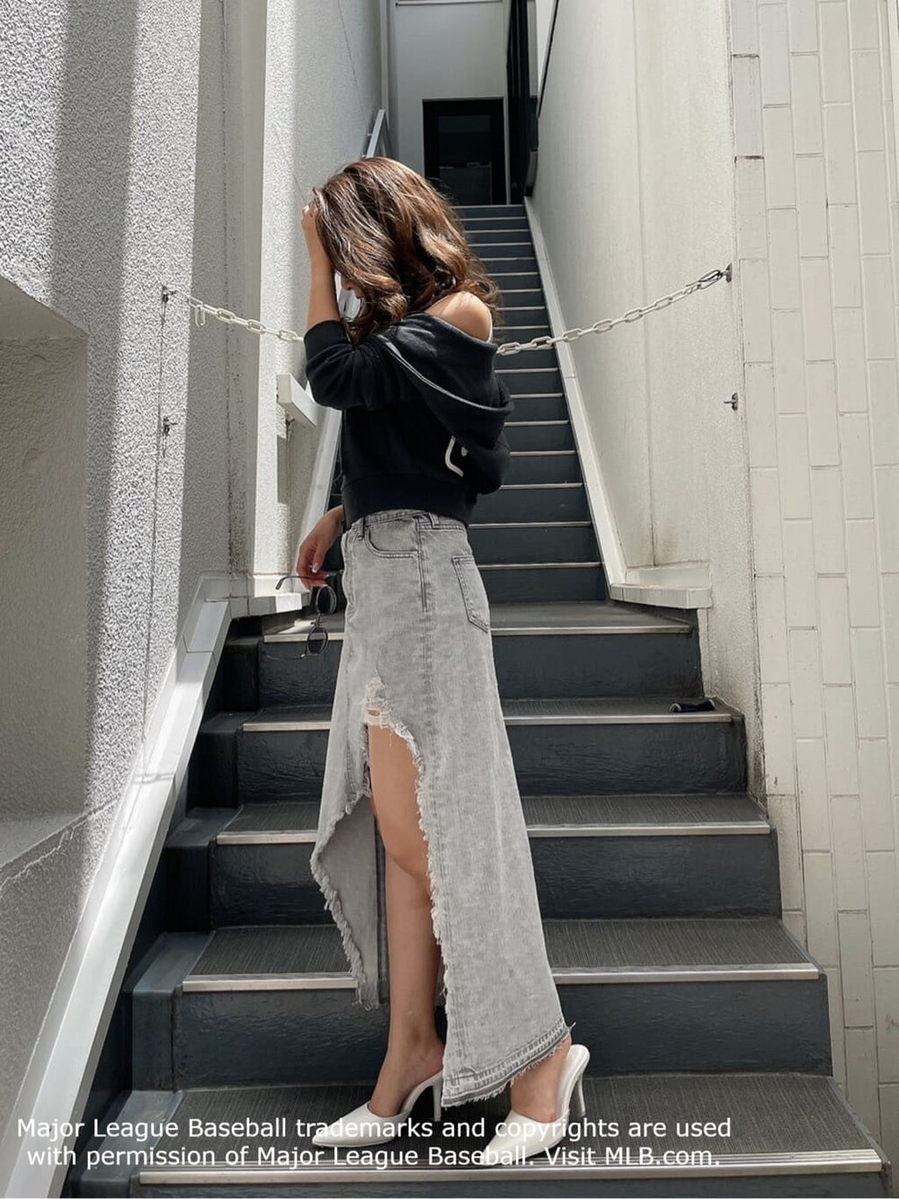 ホワイト系のパンプス、グレー系のデニムスカート、グレー系のパーカーを着用したレディースの夏コーディネートの3枚目の写真