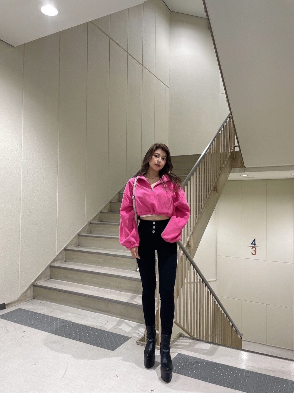 ブラック系のブーツ、ピンク系のTシャツ/カットソー、ブラック系のデニムパンツを着用したレディースの秋コーディネートの3枚目の写真