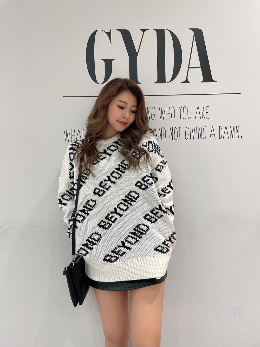 ブラック系のショルダーバッグ、ブラック系のスカート、ブラック系のその他シューズを着用したレディースの冬コーディネートの5枚目の写真