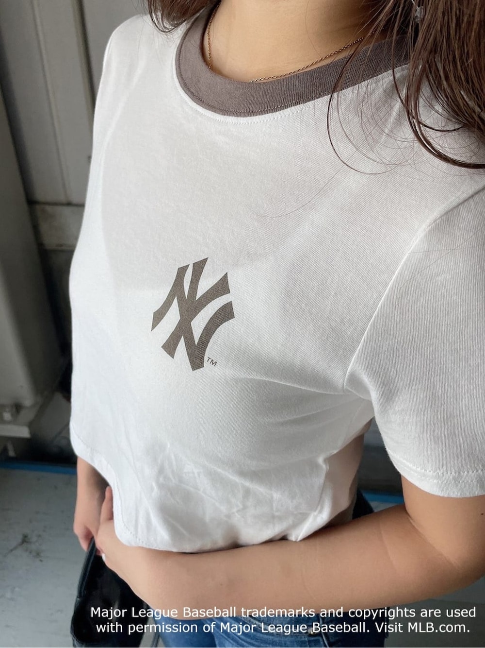 ブラック系のパンプス、ベージュ系のTシャツ/カットソー、ブルー系のデニムパンツを着用したレディースの夏コーディネートの5枚目の写真