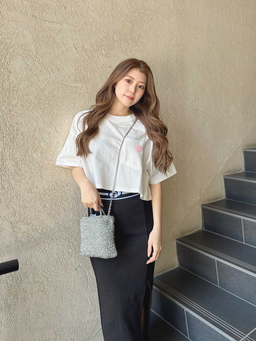 ブラック系のスカート、ホワイト系のTシャツ/カットソーを着用したレディースの春コーディネートの3枚目の写真