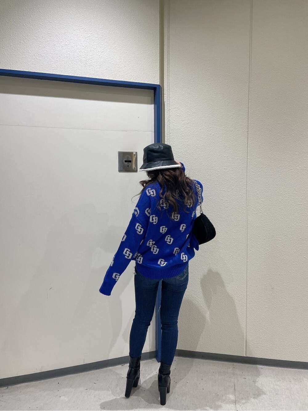 ブルー系のデニムパンツ、ブルー系のデニムパンツ、ブラック系のブーツを着用したレディースの秋コーディネートの2枚目の写真