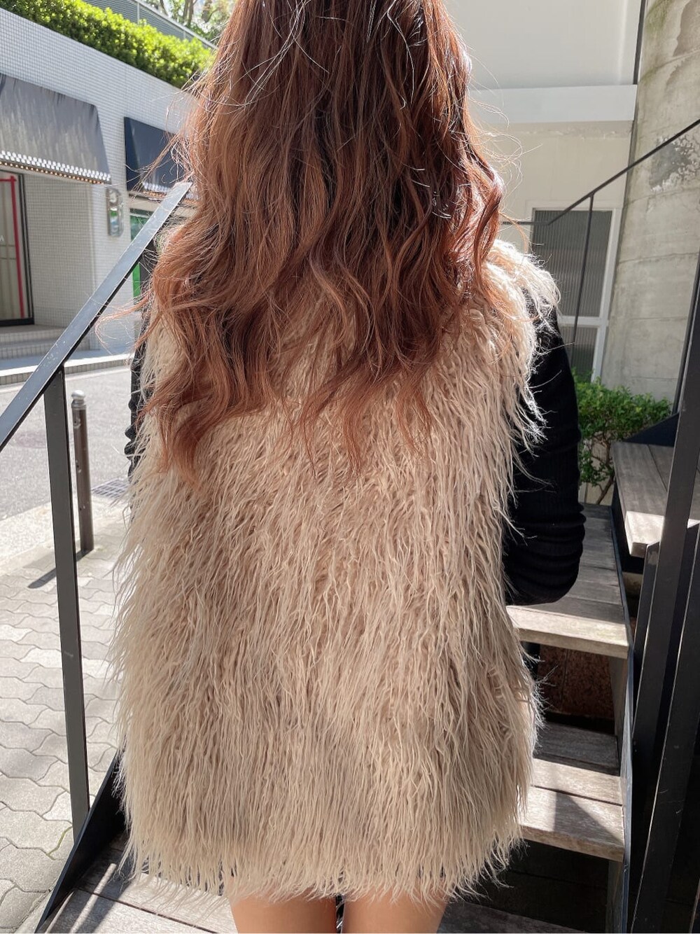 ブラック系のバックパック/リュック、ベージュ系のベスト、ブラック系のブーツを着用したレディースの秋コーディネートの10枚目の写真