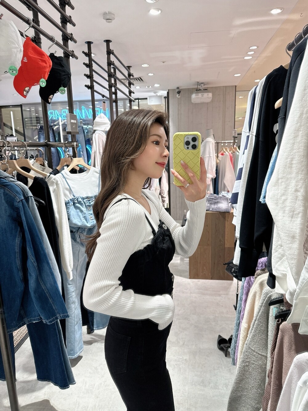 ブラック系のサロペット/オーバーオール、ホワイト系のニット/セーター、ブラック系のパンプスを着用したレディースの春コーディネートの7枚目の写真