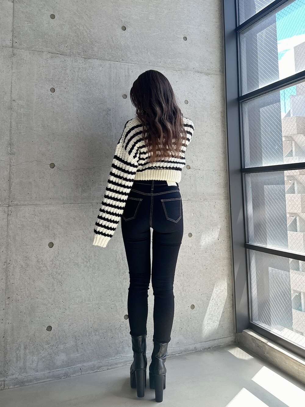 ブラック系のブーツ、ブラック系のデニムパンツ、その他のカーディガン/ボレロを着用したレディースの秋コーディネートの2枚目の写真