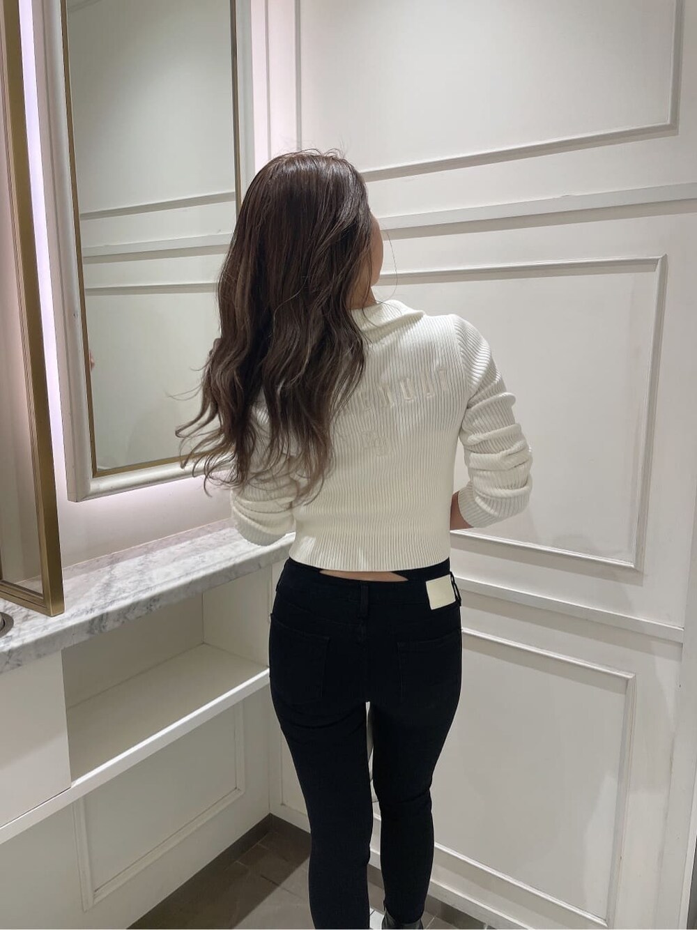 ホワイト系のバックパック/リュック、ホワイト系のニット/セーター、ブラック系のブーツを着用したレディースの秋コーディネートの4枚目の写真