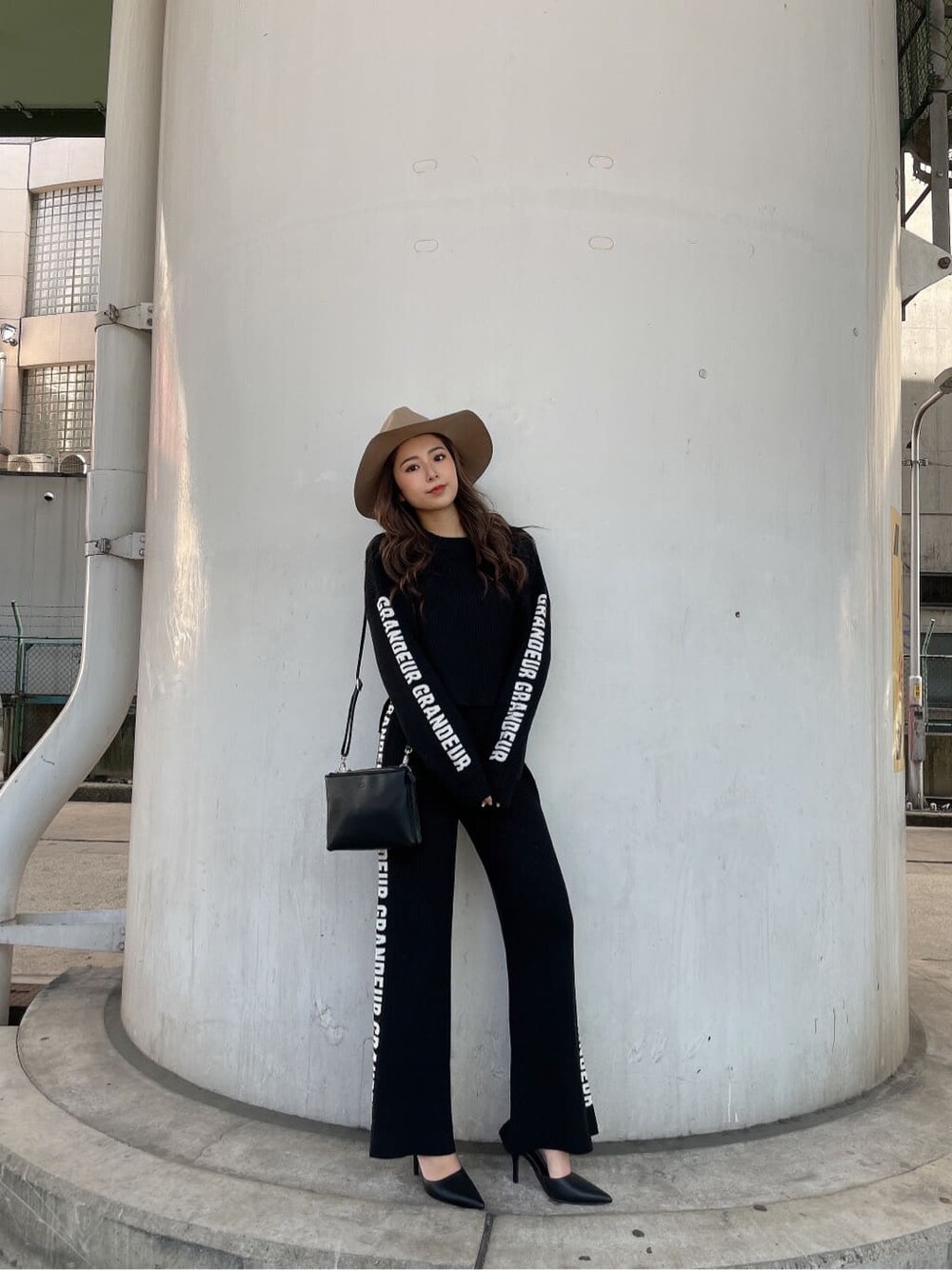 ブラック系のパンプス、ブラック系のニット/セーター、ブラック系のショルダーバッグを着用したレディースの冬コーディネートの2枚目の写真