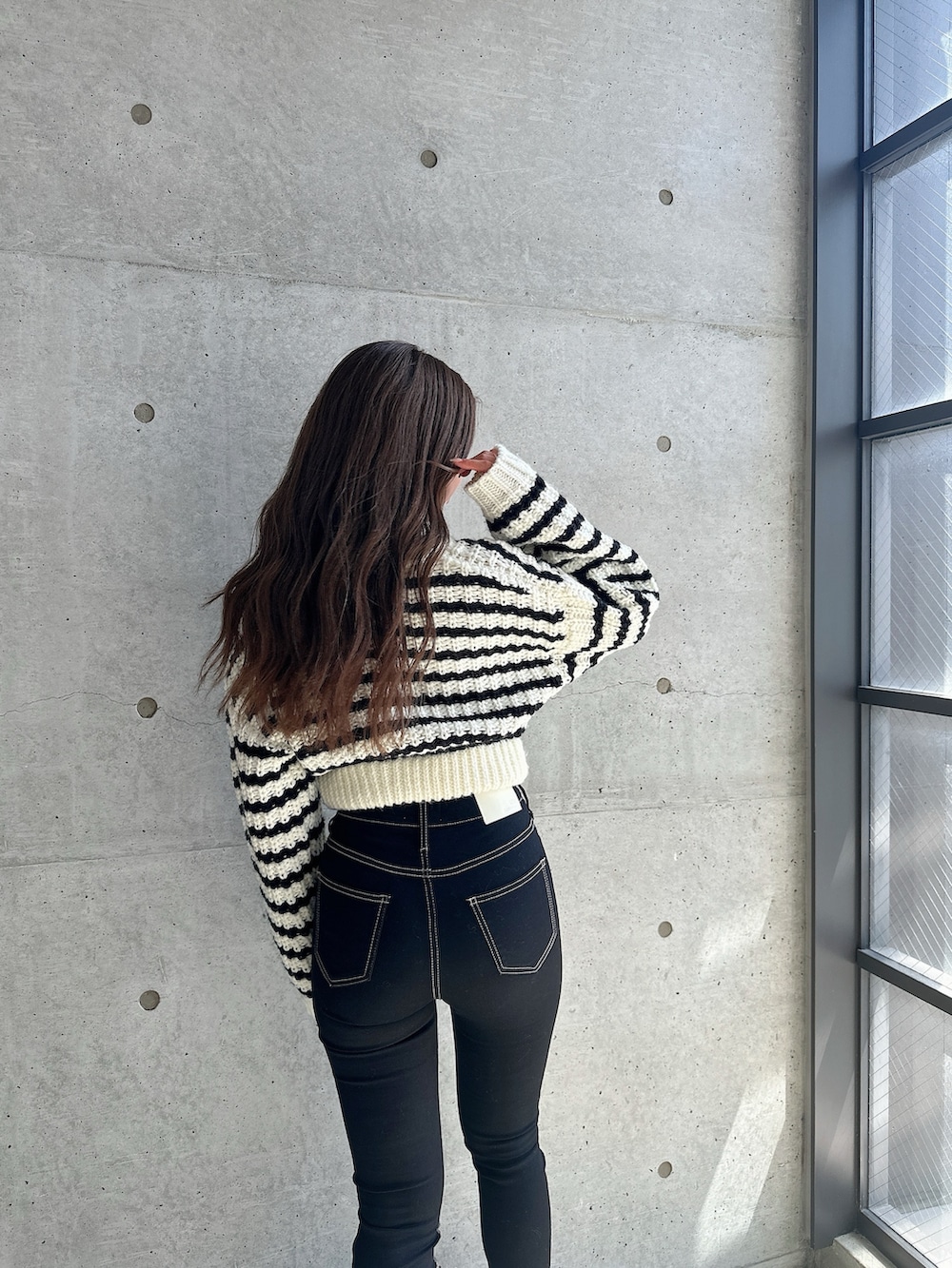 ブラック系のブーツ、ブラック系のデニムパンツ、その他のカーディガン/ボレロを着用したレディースの秋コーディネートの5枚目の写真