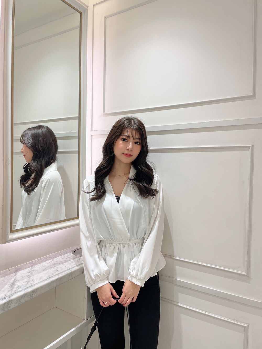 ホワイト系のシャツ/ブラウス、ブラック系のデニムパンツ、ホワイト系のハンドバッグを着用したレディースの冬コーディネートの5枚目の写真