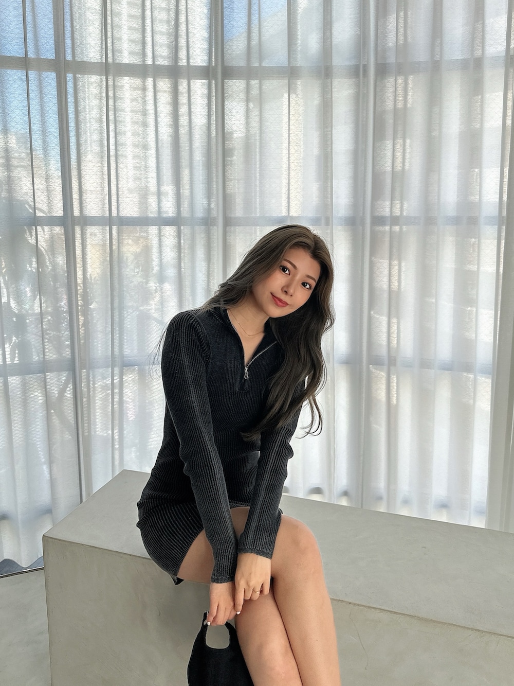 ブラック系のワンピース、ブラック系のブーツ、ブラック系のキャップを着用したレディースの秋コーディネートの4枚目の写真