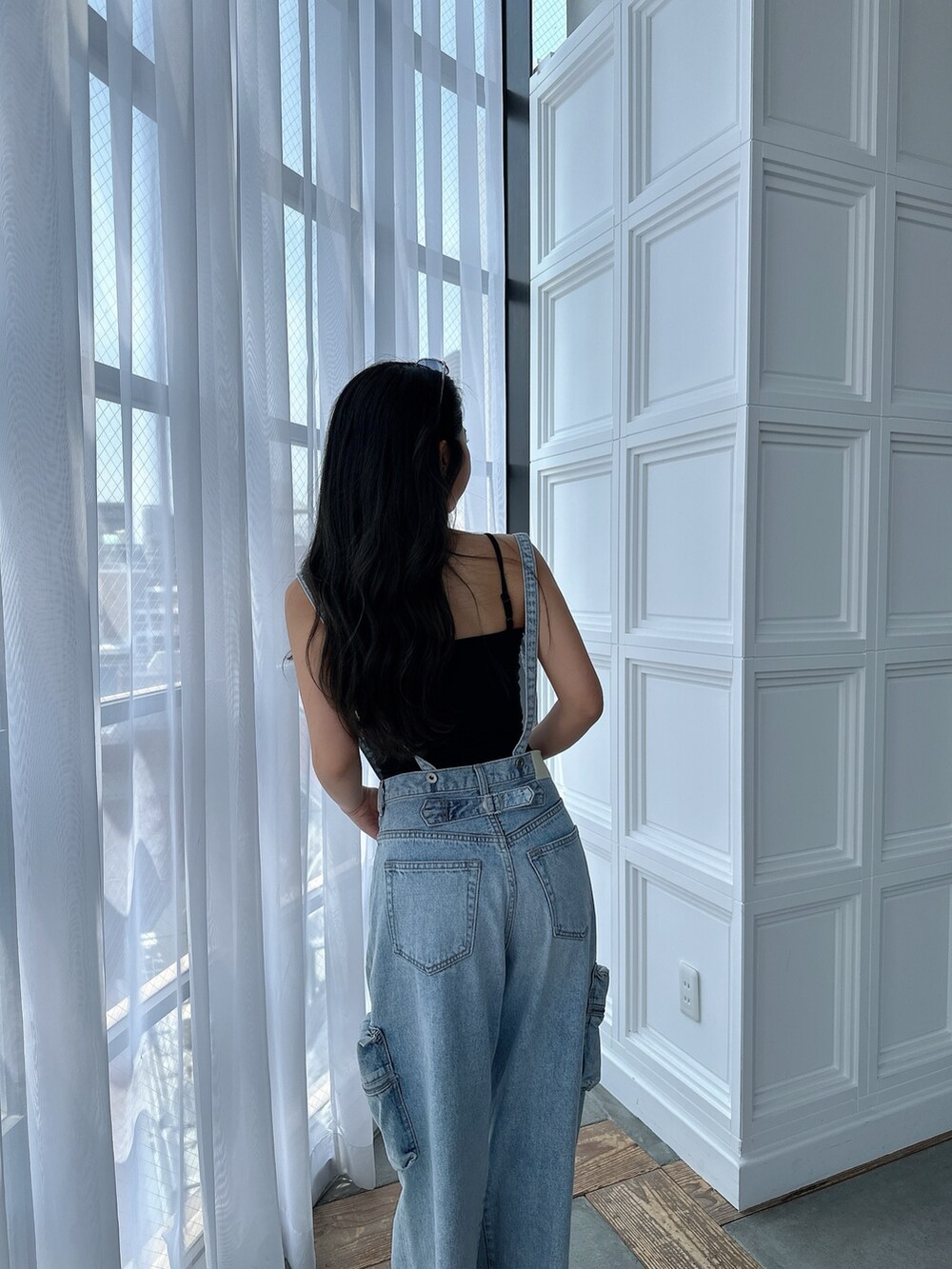 ブラック系のキャミソール、ブルー系のデニムパンツ、ブラック系のサンダルを着用したレディースの夏コーディネートの8枚目の写真