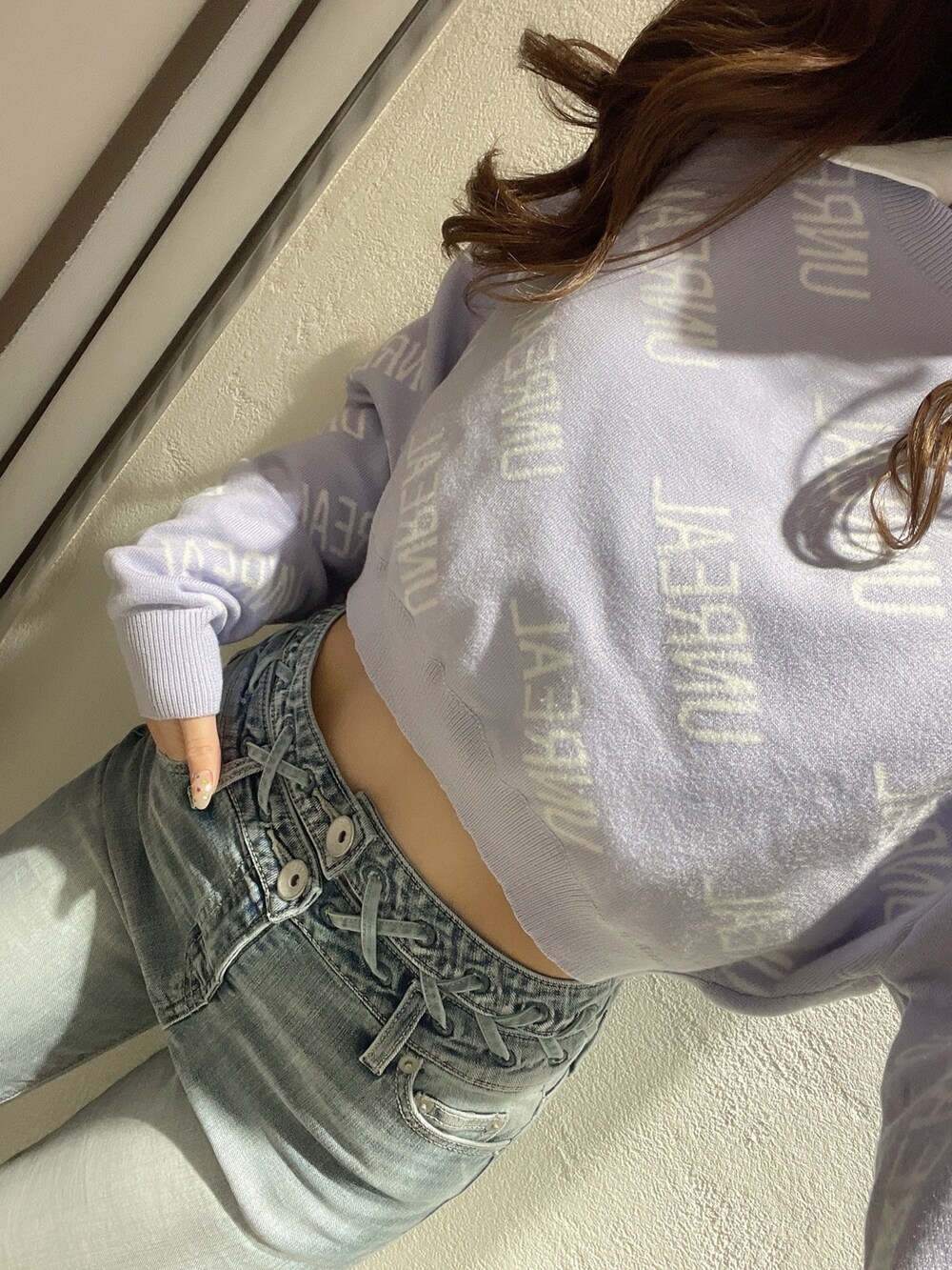 パープル系のニット/セーター、ホワイト系のシャツ/ブラウス、ブルー系のデニムパンツを着用したレディースの冬コーディネートの7枚目の写真