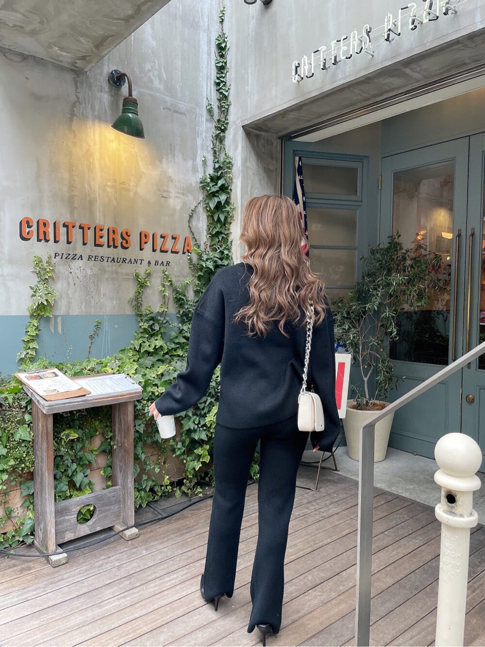 ホワイト系のショルダーバッグ、ブラック系のパンプス、ブラック系のその他パンツを着用したレディースの冬コーディネートの4枚目の写真