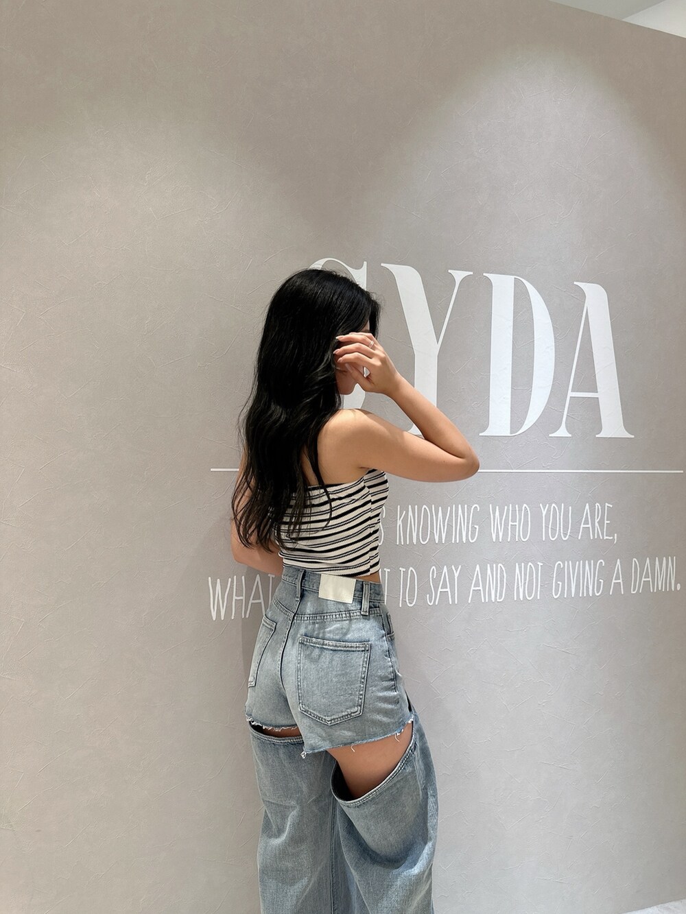 ホワイト系のキャミソール、ブルー系のデニムパンツ、ホワイト系のサンダルを着用したレディースの夏コーディネートの2枚目の写真