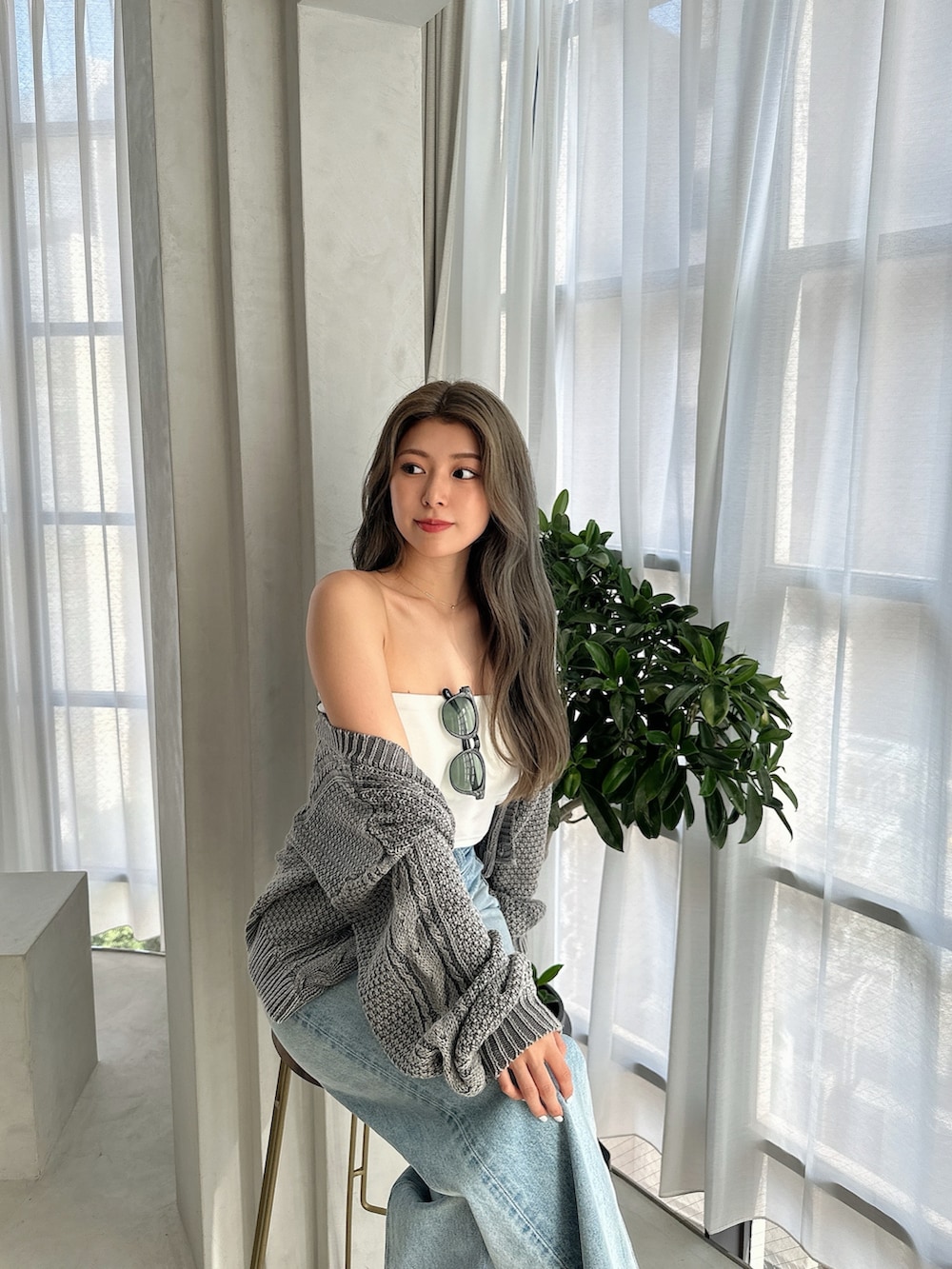 ブルー系のニット/セーター、ブルー系のデニムパンツ、ホワイト系のパンプスを着用したレディースの夏コーディネートの5枚目の写真