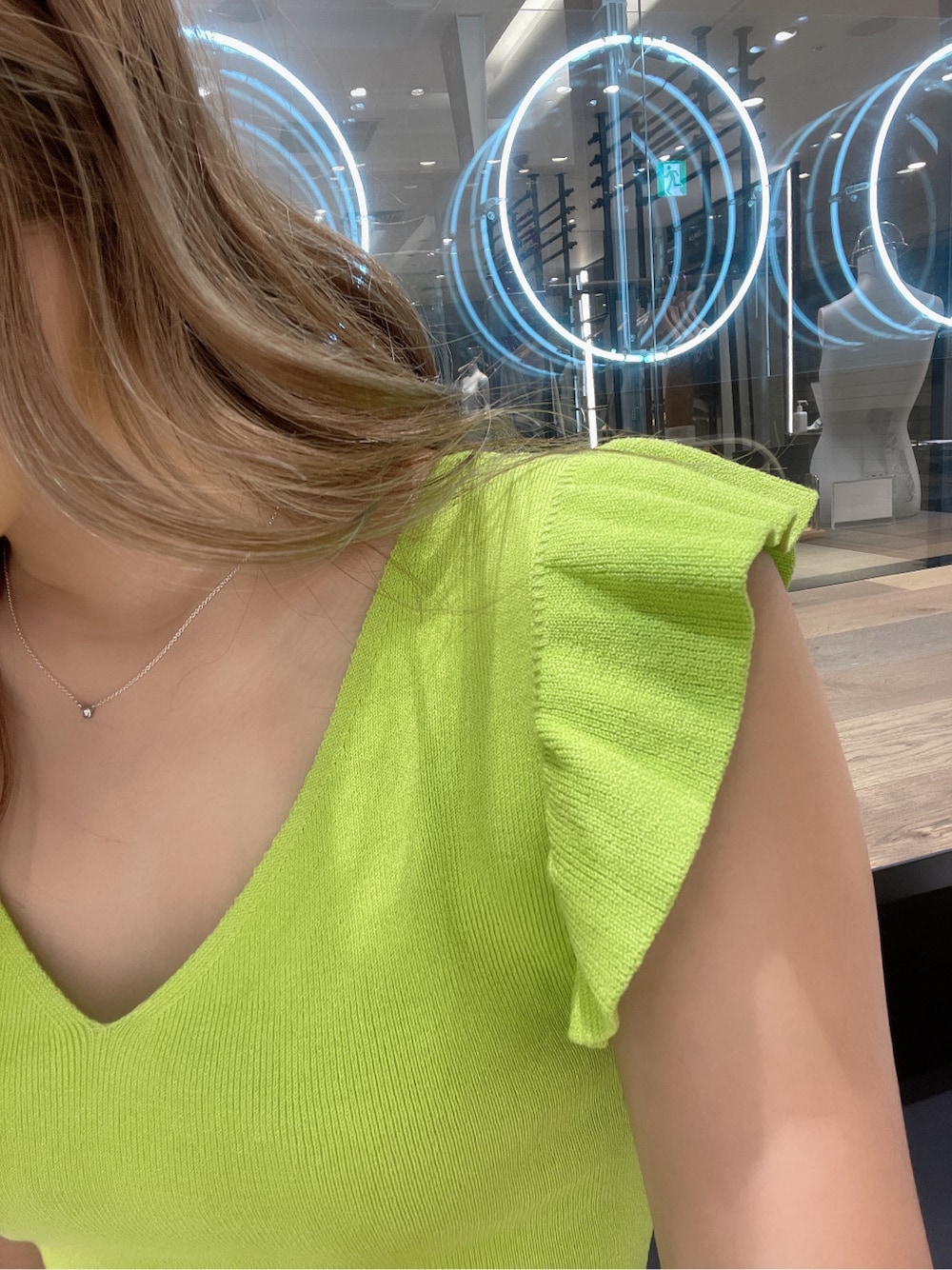 グリーン系のニット/セーターを着用したレディースの春コーディネートの2枚目の写真