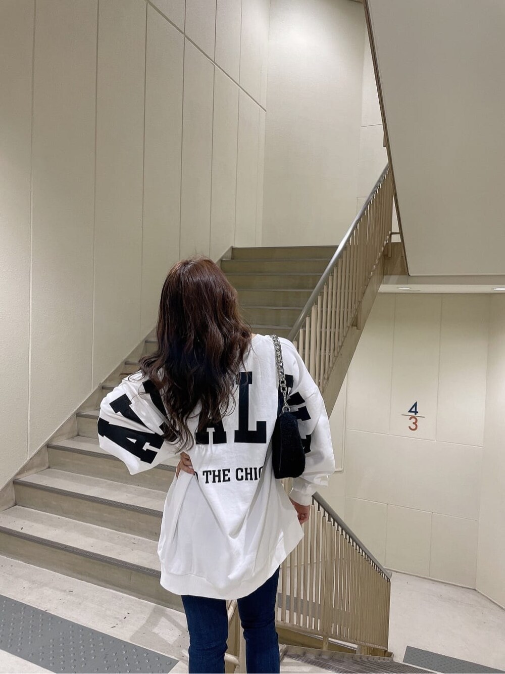 ブルー系のデニムパンツ、ブルー系のデニムパンツ、ブラック系のブーツを着用したレディースの秋コーディネートの7枚目の写真