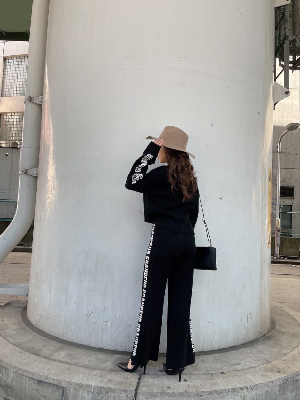 ブラック系のパンプス、ブラック系のニット/セーター、ブラック系のショルダーバッグを着用したレディースの冬コーディネートの3枚目の写真