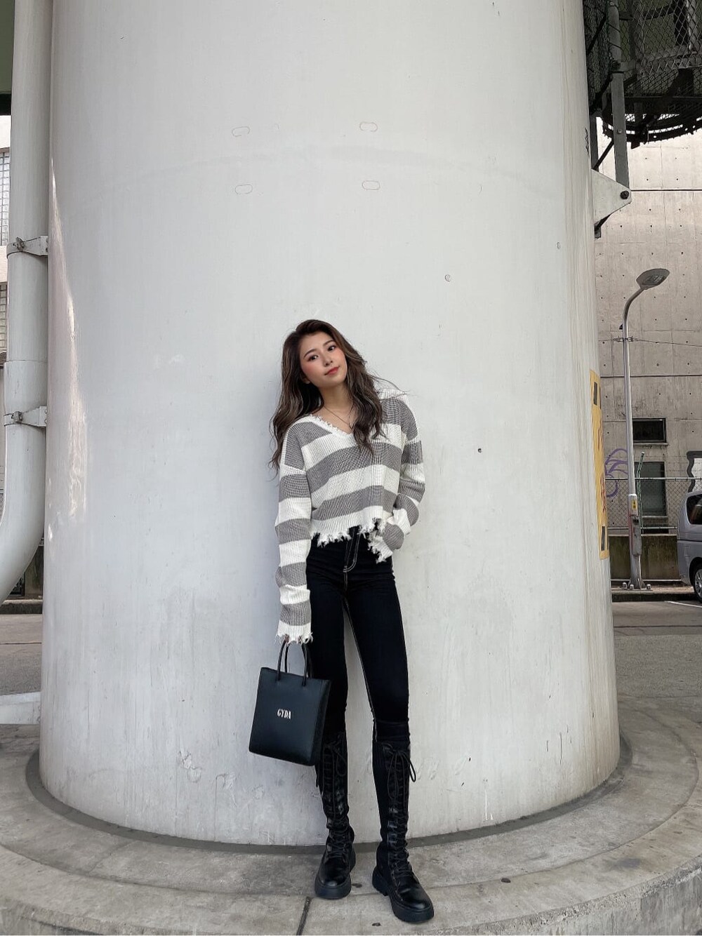 ブラック系のショルダーバッグ、ブラック系のデニムパンツ、グレー系のニット/セーターを着用したレディースの秋コーディネートの2枚目の写真