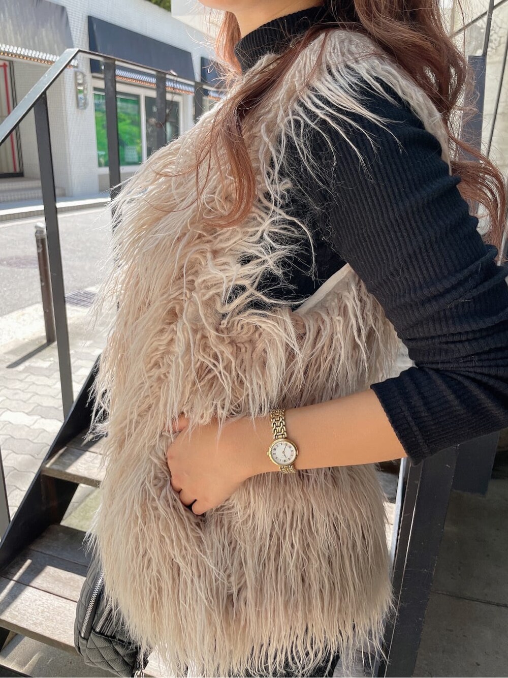 ブラック系のバックパック/リュック、ベージュ系のベスト、ブラック系のブーツを着用したレディースの秋コーディネートの9枚目の写真