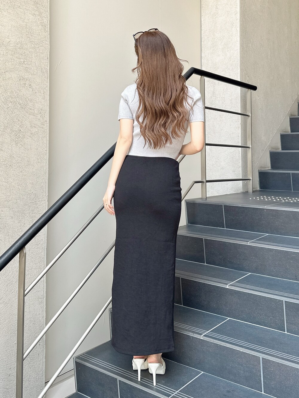 ホワイト系のパンプス、ブラック系のスカート、シルバー系のニット/セーターを着用したレディースの春コーディネートの3枚目の写真