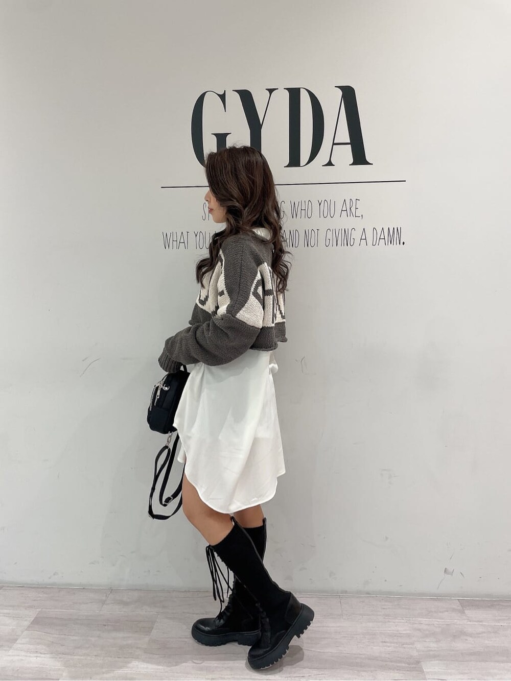 ブラック系のその他シューズ、ブラック系のバックパック/リュック、ホワイト系のシャツ/ブラウスを着用したレディースの冬コーディネートの4枚目の写真