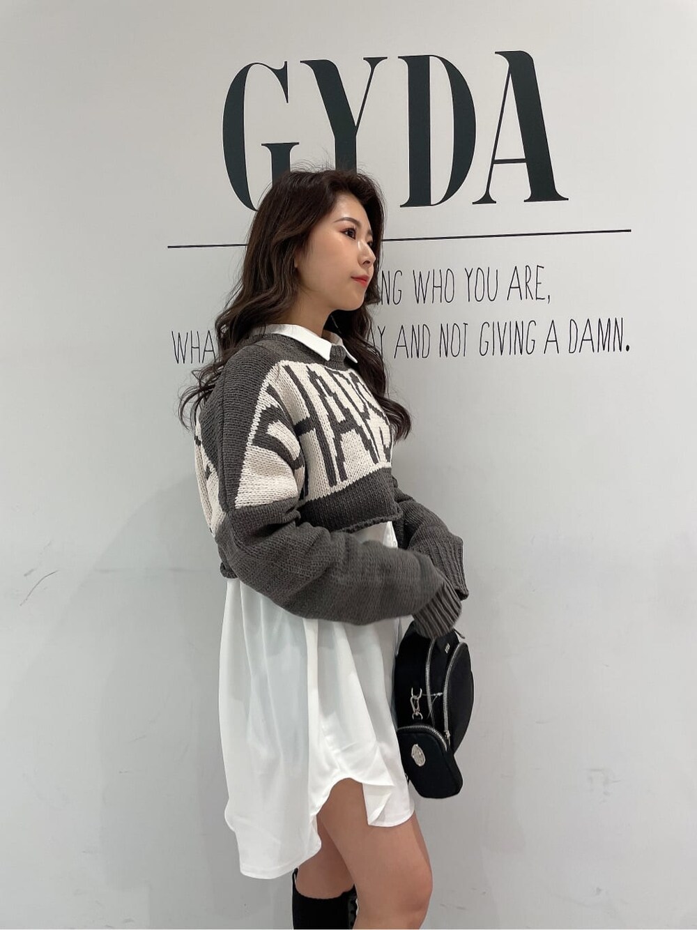 ブラック系のその他シューズ、ブラック系のバックパック/リュック、ホワイト系のシャツ/ブラウスを着用したレディースの冬コーディネートの8枚目の写真