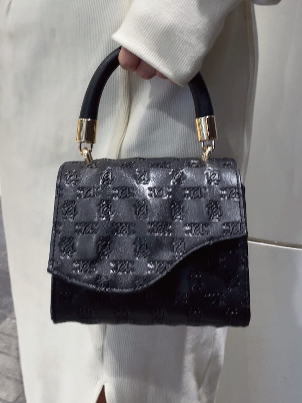 ホワイト系のワンピース、ブラック系のハンドバッグ、ブラック系のパンプスを着用したレディースの冬コーディネートの7枚目の写真