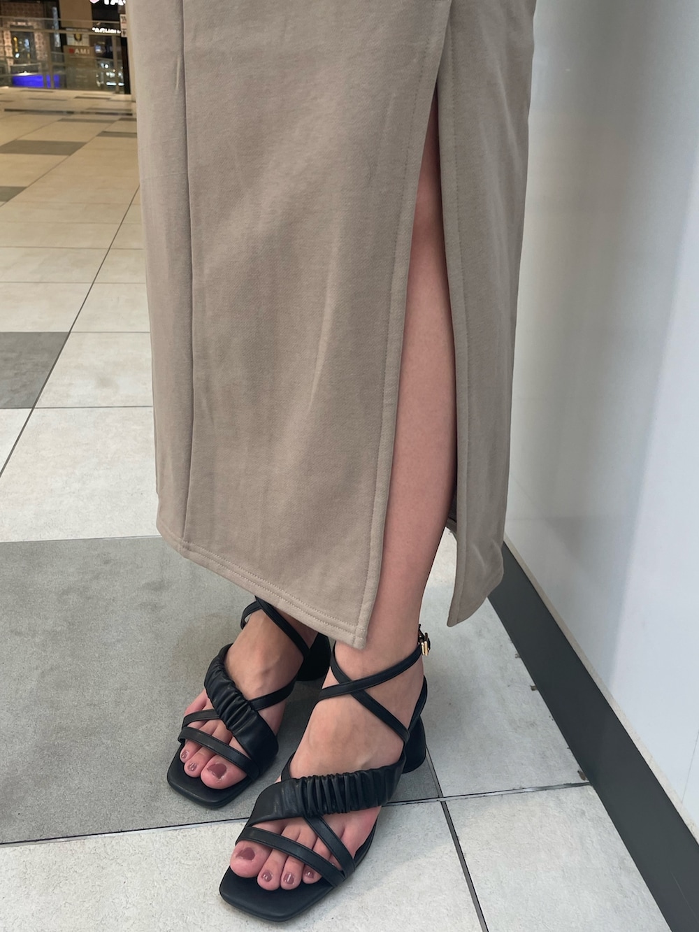 ベージュ系のワンピース、ブラック系のハンドバッグ、ブラック系のサンダルを着用したレディースの春コーディネートの4枚目の写真