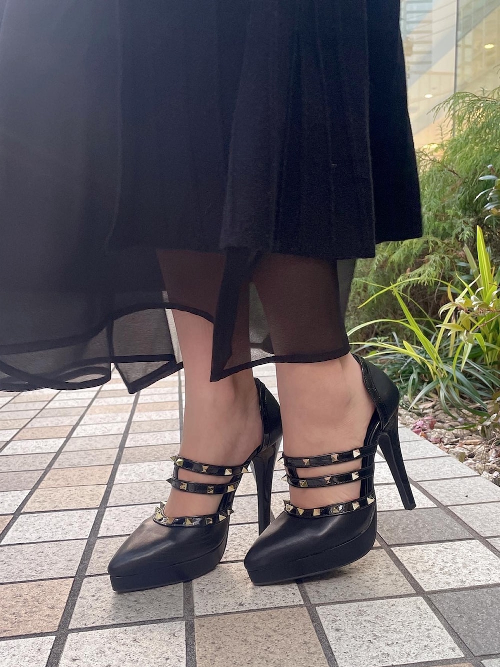 ブラック系のハンドバッグ、ブラック系のパンプス、ブラック系のワンピースを着用したレディースの冬コーディネートの4枚目の写真