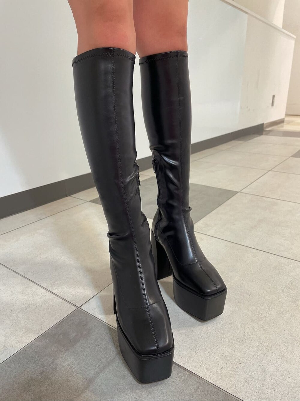 ブラック系のブーツ、ブラック系のスカート、ホワイト系のカーディガン/ボレロを着用したレディースの秋コーディネートの7枚目の写真