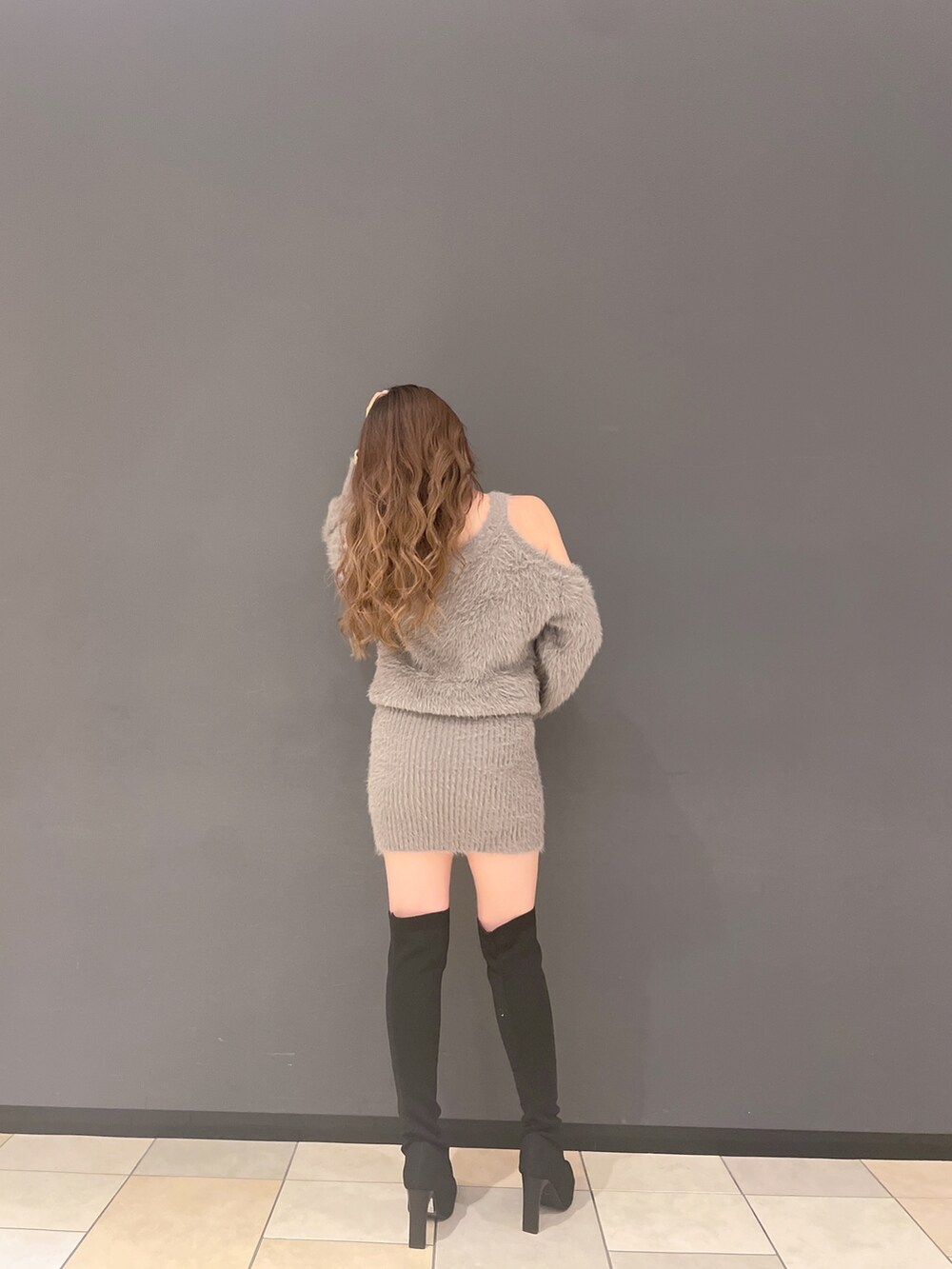 ベージュ系のワンピース、ブラック系のブーツを着用したレディースの秋コーディネートの2枚目の写真