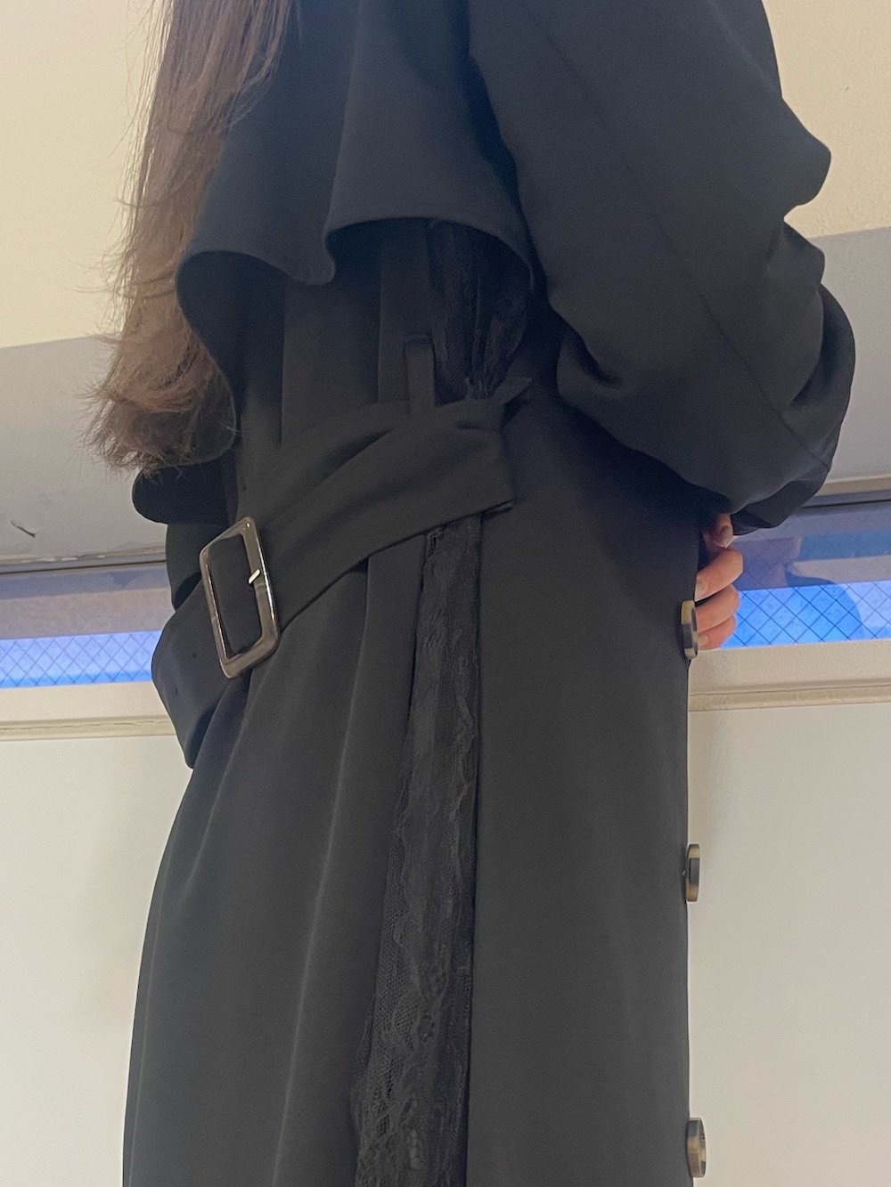 ブラック系のトレンチコート、ブラック系のニット/セーター、ブラック系のハンドバッグを着用したレディースの春コーディネートの4枚目の写真