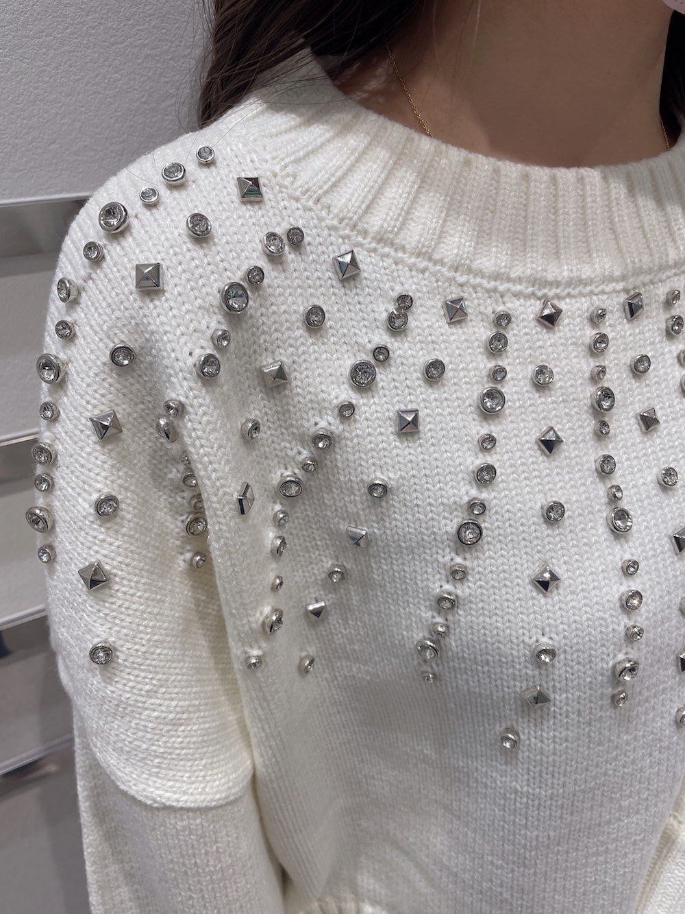 ホワイト系のニット/セーター、ブルー系のデニムパンツ、ブラック系のパンプスを着用したレディースの冬コーディネートの4枚目の写真