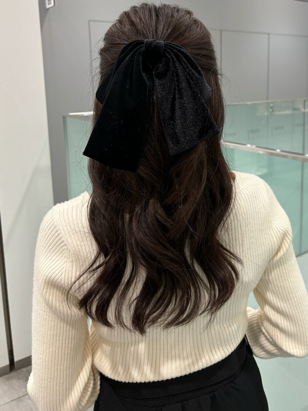 ホワイト系のニット/セーター、ブラック系のスカート、ブラック系のブーツを着用したレディースの冬コーディネートの5枚目の写真