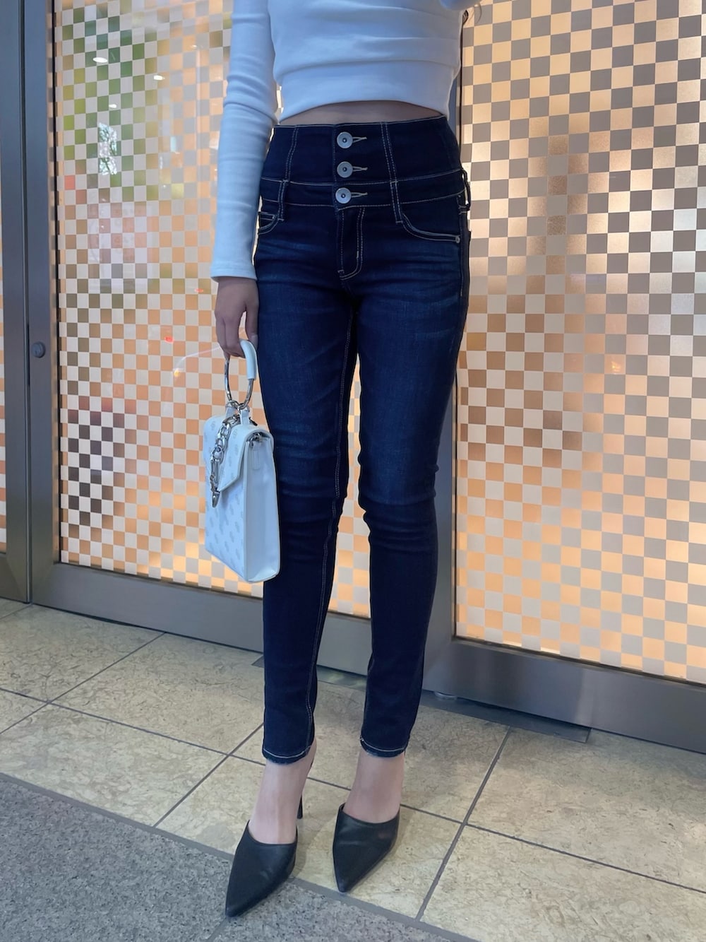 グレー系のライダースジャケット、ホワイト系のTシャツ/カットソー、ブルー系のデニムパンツを着用したレディースの冬コーディネートの6枚目の写真