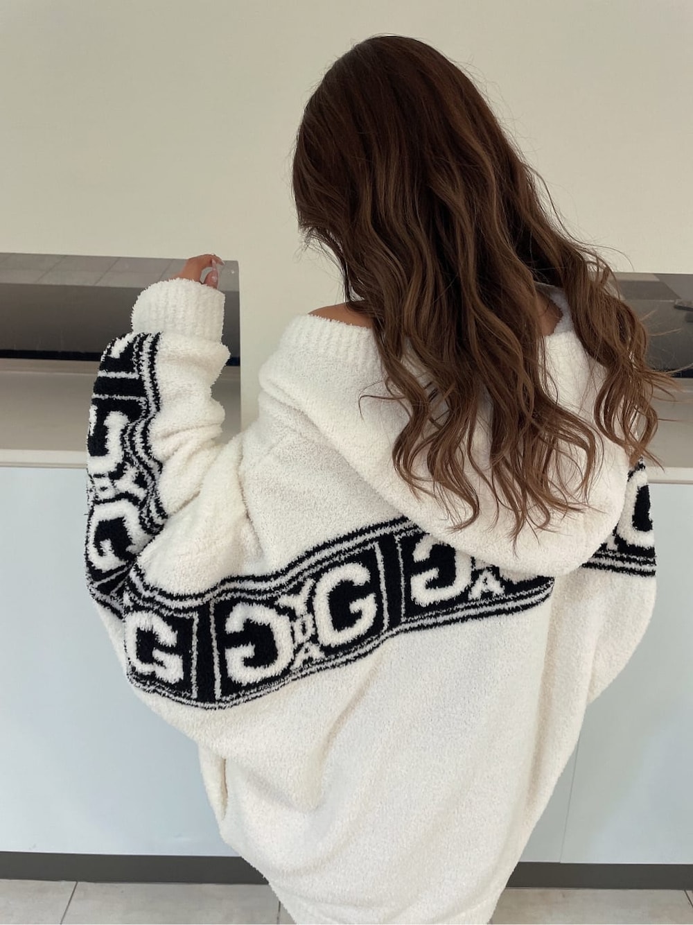 ブラック系のブーツ、ブラック系のスカート、ホワイト系のカーディガン/ボレロを着用したレディースの秋コーディネートの3枚目の写真