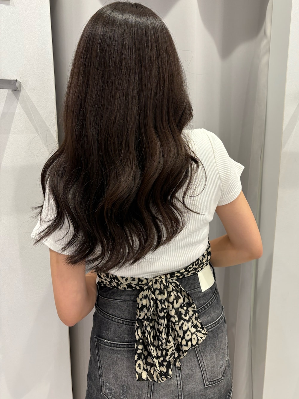 ブラック系のサンダル、ホワイト系のTシャツ/カットソー、ブラック系のデニムスカートを着用したレディースの夏コーディネートの4枚目の写真