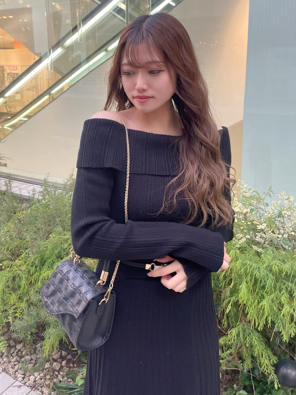 ブラック系のハンドバッグ、ブラック系のパンプス、ブラック系のワンピースを着用したレディースの冬コーディネートの5枚目の写真