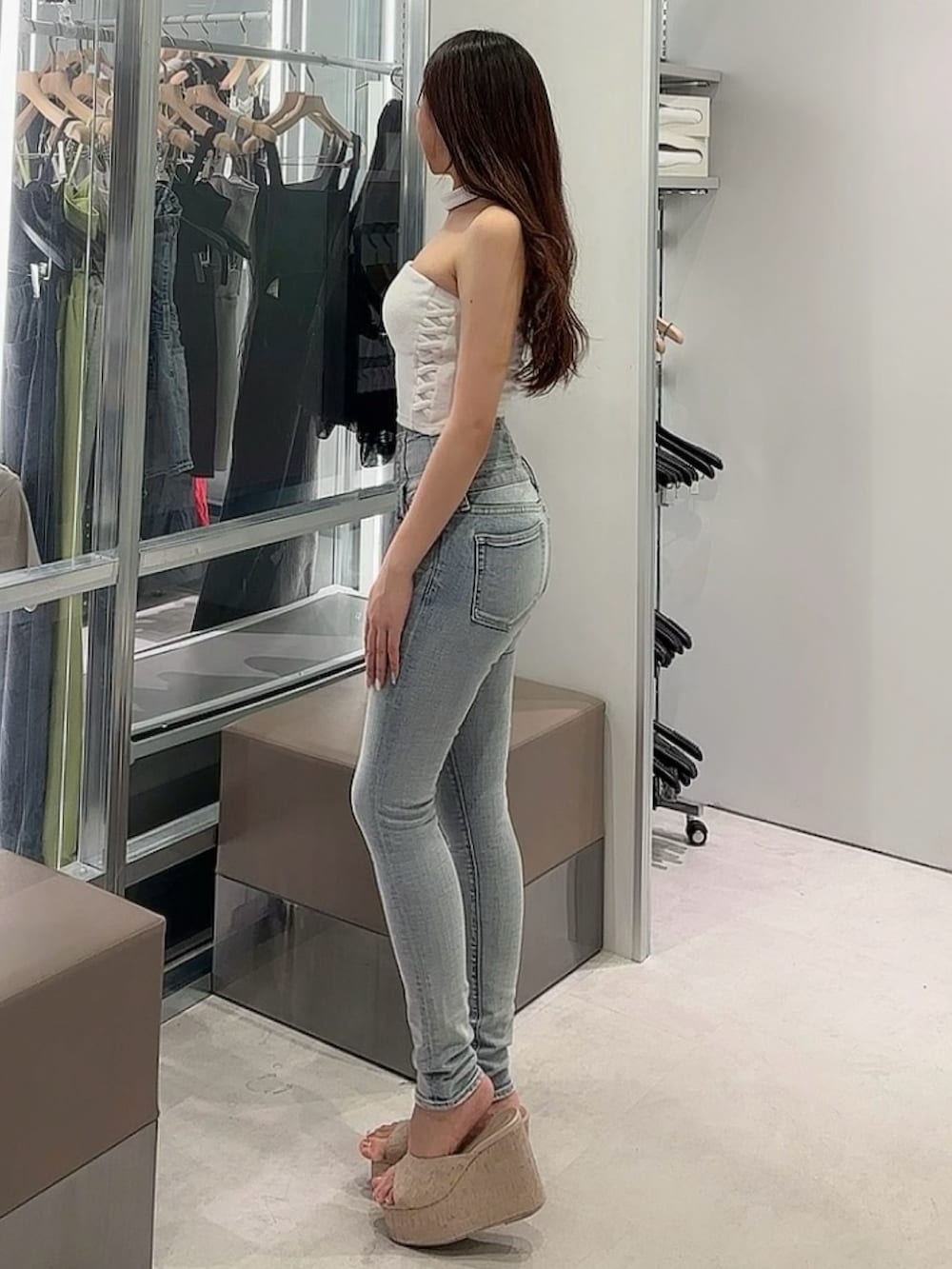 ホワイト系のサンダル、ホワイト系のチューブトップ、ブルー系のデニムパンツを着用したレディースの夏コーディネートの3枚目の写真