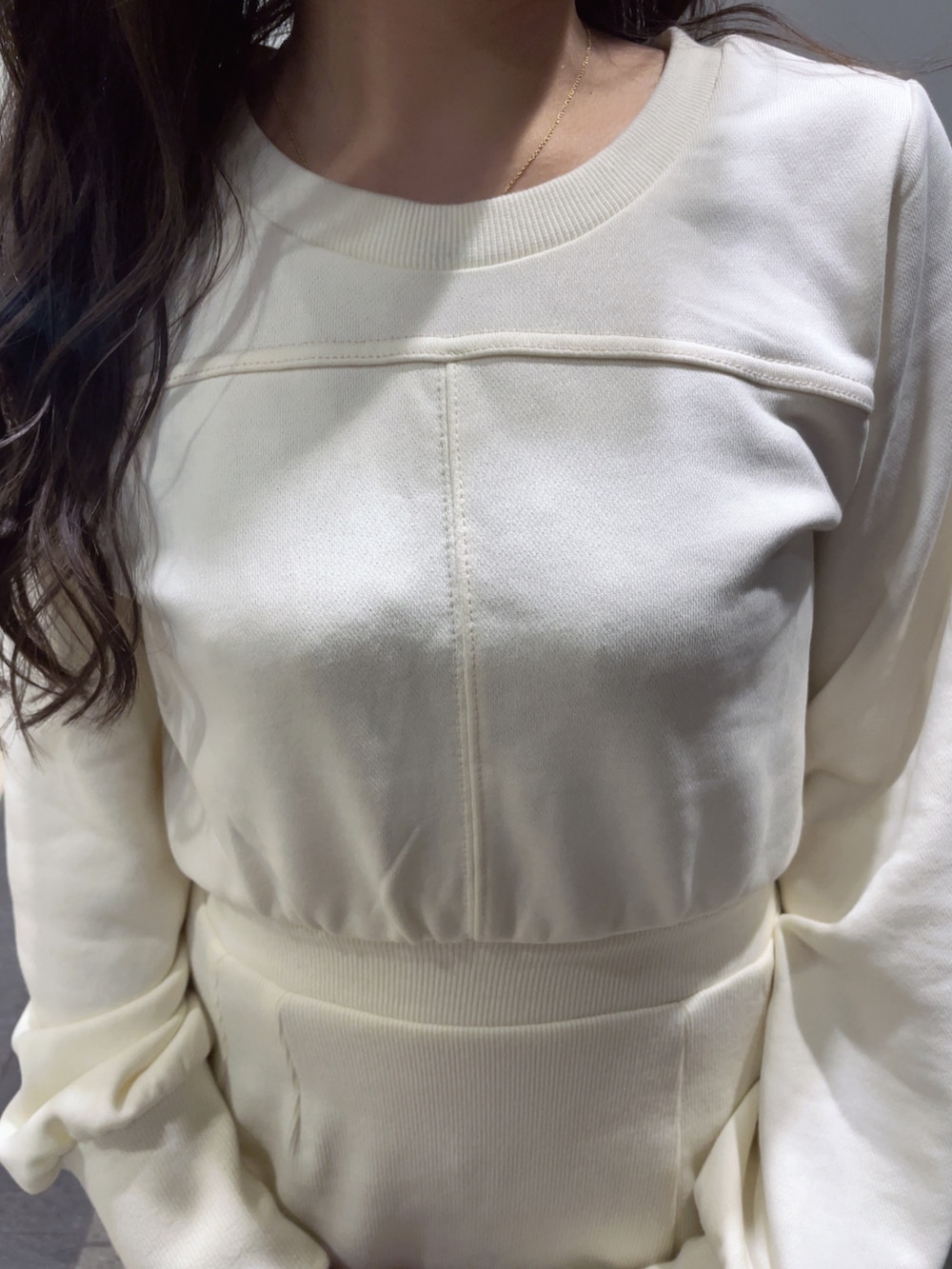 ホワイト系のワンピース、ブラック系のハンドバッグ、ブラック系のパンプスを着用したレディースの冬コーディネートの4枚目の写真