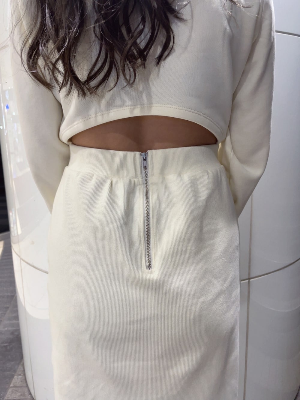 ホワイト系のワンピース、ブラック系のハンドバッグ、ブラック系のパンプスを着用したレディースの冬コーディネートの5枚目の写真