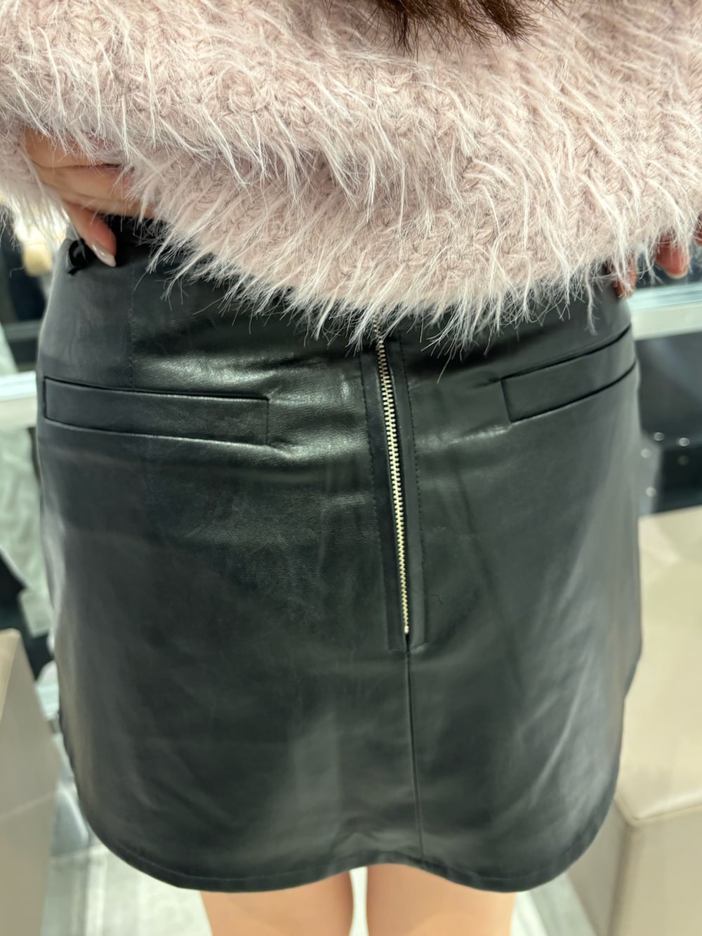 ブラック系のスカート、ピンク系のニット/セーター、ブラック系のブーツを着用したレディースの秋コーディネートの6枚目の写真