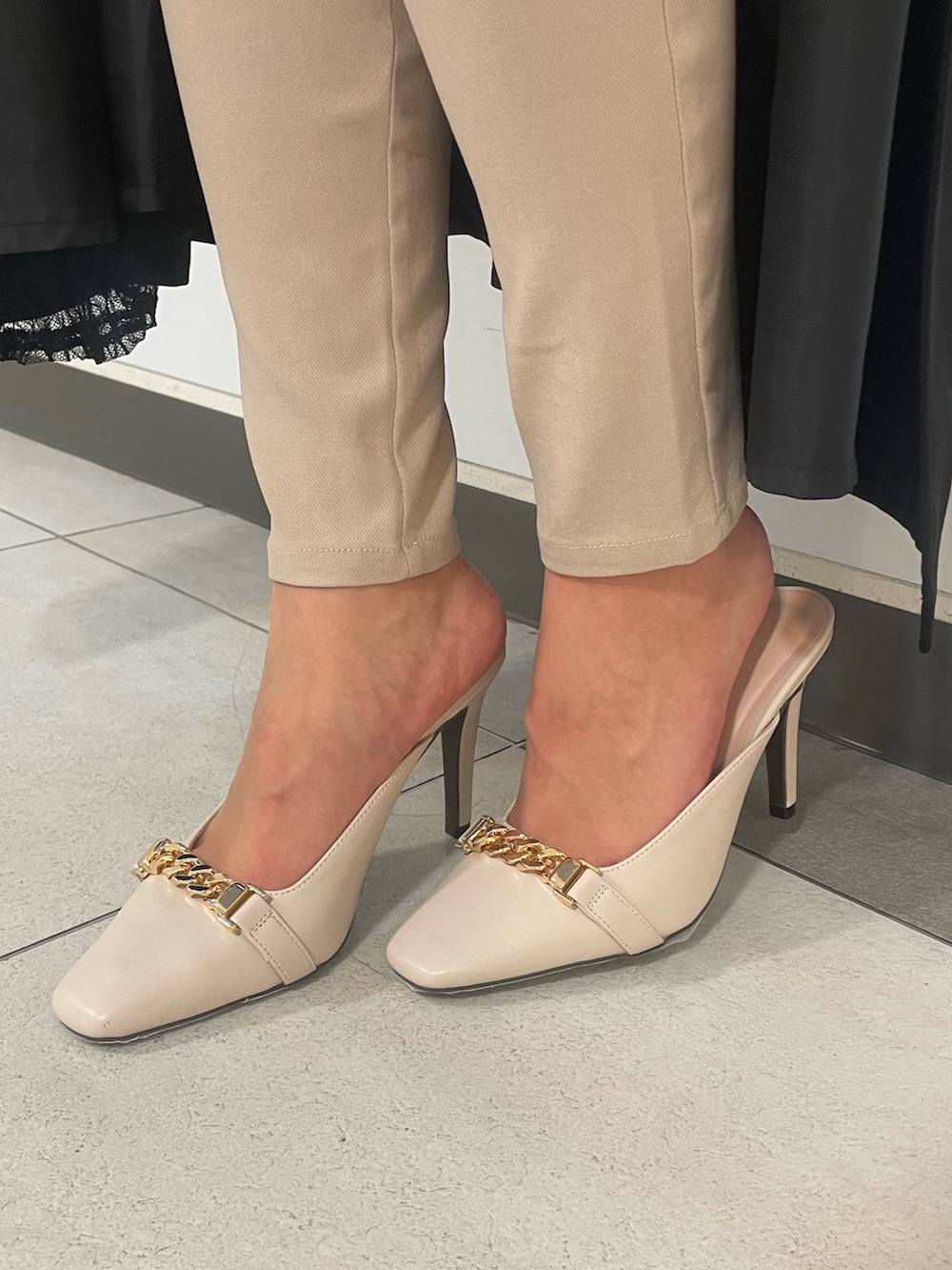 ブラック系のトレンチコート、ブラック系のニット/セーター、ブラック系のハンドバッグを着用したレディースの春コーディネートの5枚目の写真