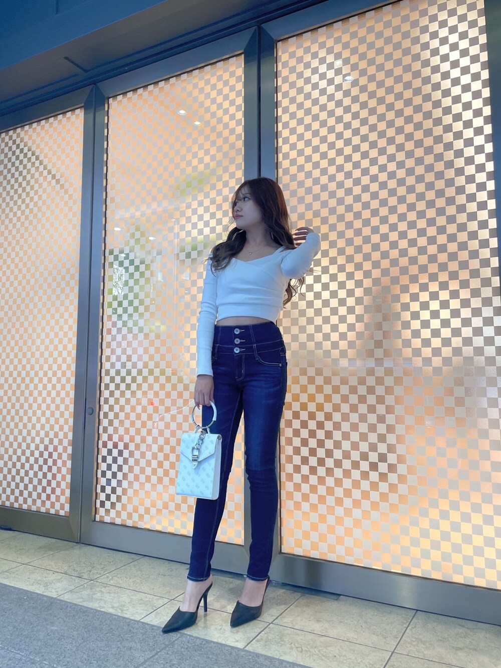 グレー系のライダースジャケット、ホワイト系のTシャツ/カットソー、ブルー系のデニムパンツを着用したレディースの冬コーディネートの2枚目の写真